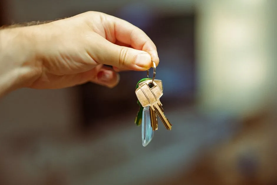 Close-up of a hand holding keys to a new home, illustrative of the private-market rental a Housing Choice Voucher helps pay for